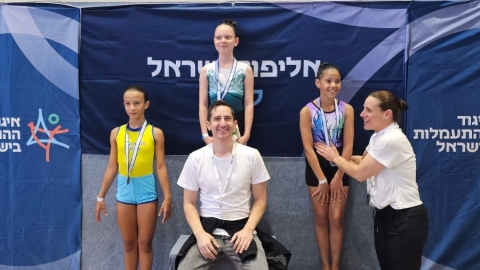 תמר דוקטורי עומדת על הפודיום ומתחתיה המאמן.jpg