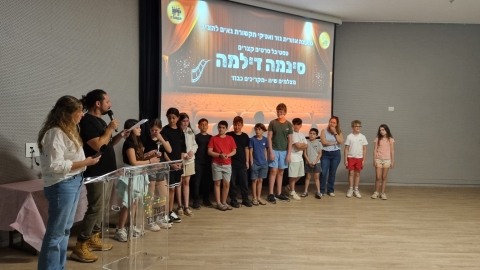 קבוצת תלמידים שהפיקה יחד סרט עומדים על הבמה בתום ההקרנה.jpg