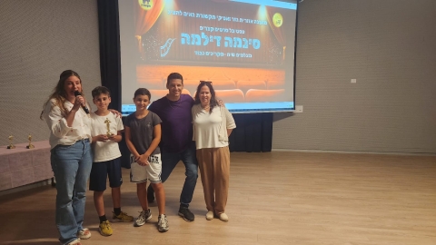 ילדים מחזיקים פסלון שקיבלו על הבמה.jpg