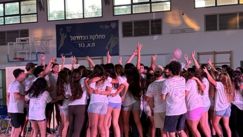 תלמידים קופצים ומתחבקים במסיבת הסיום בתיכון איתן.jpg