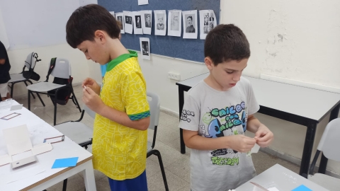 ילדים גוזרים ומדביקים.jpeg