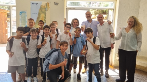 תמונה קבוצתית של ראשת המועצה ומנהלת אגף החינוך עם תלמידים ומחנך מישיבה תיכונית עלבים כולם מחזיקים גל
