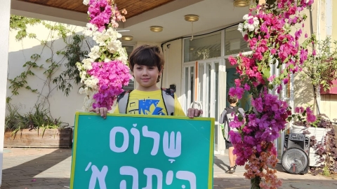 ילד מחזיק שלט שלום כיתה א בבית ספר דרור.jpg