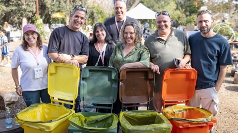 ראשת המועצה עם צוות ההפקה של האירוע לצד פחי המחזור שהוצבו ברחבי המקום.jpg