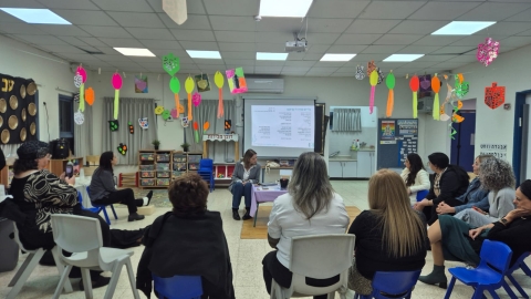 מנהלת מחלקת גני הילדים מדברת עם הגננות במפגש.jpeg