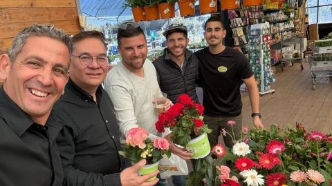 אנשים מחייכים ליד שתילי פרחים.jpg