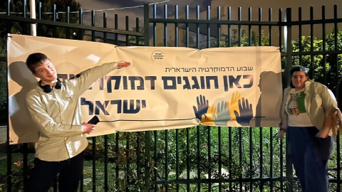 חניכים עם שלט של שבוע הדמוקרטיה בחינוך הבלתי פורמלי.jpeg