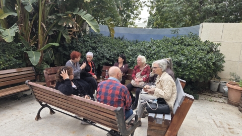 ותיקות וותיקים יושבים בחצר.jpg