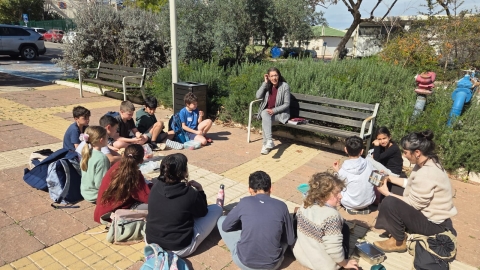 תלמידים יושבים עם שרון מהדיגיטל על פעולת שקשורה במוקד המועצה.jpeg