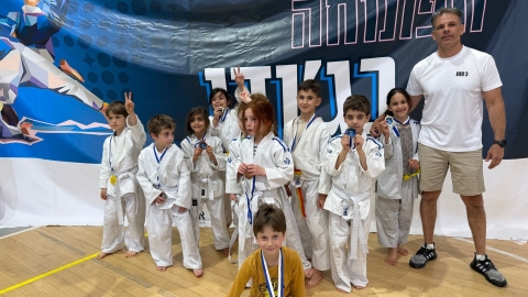 ילדים עם מדליות יחד עם המאמן יוסי ליפמן.jpg