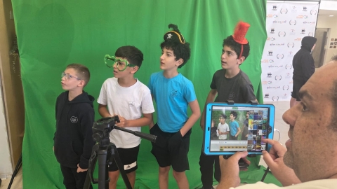 תלמידים מצטלמים בעמדת מסך ירוק.jpeg