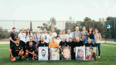 צילום קבוצתי של החברים והמשפחה עם תמונות החברים שהערב הזה נעשה לזכרם.jpeg