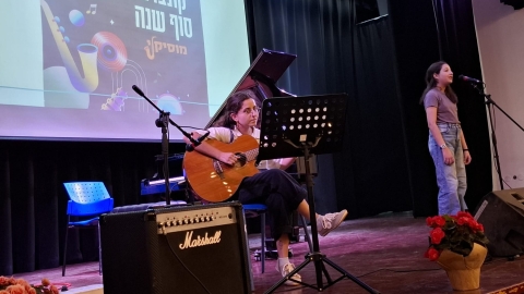 תלמידה מנגנת על גיטרה ותלמידה שרה.jpeg