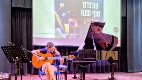 תלמידה מנגנת על גיטרה.jpeg