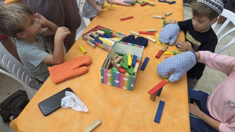 ילדים עם כפפות מנסים לבנות מגדל.jpg